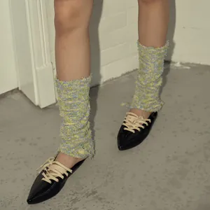 Colorful chunky knit leg warmers paired with black patent leather ballerina flats