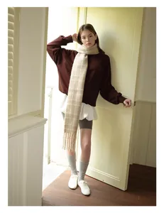 Detailed styling of a soft red plaid wool blend scarf paired with a casual sweatshirt