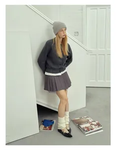 Lifestyle shot of model wearing a light grey wool knitted beanie with matching winter outfit