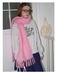 Close-up of thick pink wool scarf with long tassels paired with a casual sweatshirt