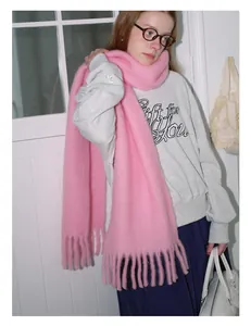 Close-up of thick pink wool blend scarf with decorative fringe tassels for winter warmth