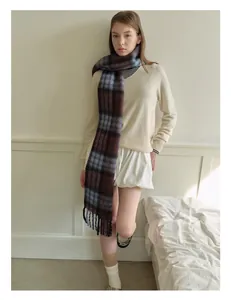Detailed view of British plaid wool blend scarf with fringe tassels and soft texture