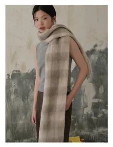 Detail van zachte alpaca wolmix sjaal met klassieke grijs en beige ruit en franjes aan de rand