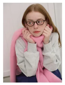 Close-up of a soft pink wool scarf paired with a grey sweatshirt and glasses
