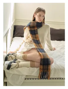 Detail view of winter scarf featuring British plaid pattern and soft wool blend fringe