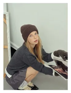 Detail of premium brown rib-knit wool beanie and matching gloves in a cozy winter outfit