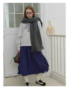 Gray wool scarf with tassels paired with gray sweatshirt and navy pleated maxi skirt