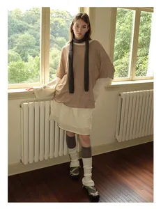 Detail eines grauen Wollschals kombiniert mit Strickpullover und Spitzenrock