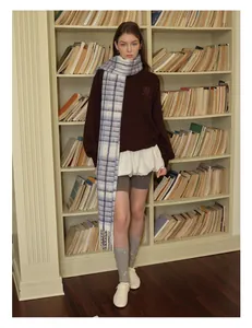 Winter outfit with blue checkered wool scarf, brown sweatshirt and white pleated skirt