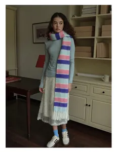 Gros plan sur une écharpe rayée pastel en laine mélangée avec de longs fils à franges