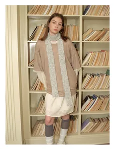 Detail shot of a grey wool blend skinny scarf styled with a beige T-shirt and lace skirt