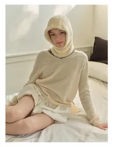 Close-up of fluffy beige faux mink balaclava and matching warm knitted sweater texture