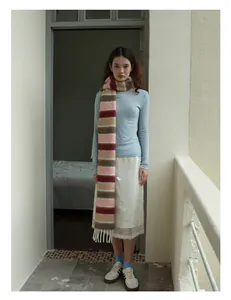 Détail d'une écharpe en laine mélangée à rayures colorées et franges blanches