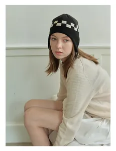Detail of knit ear protection beanie featuring black and white checkerboard pattern texture
