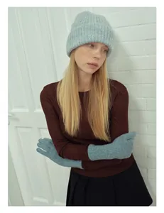 Dettaglio del set berretto e guanti in lana alpaca azzurro con trama a maglia verticale