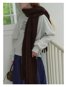 Detailed texture of thick dark brown wool scarf with long fringe and soft mohair finish