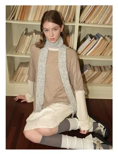 Close-up of the plush texture of a grey wool blend scarf on a fashion model styling
