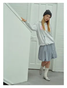 Fashionable grey wool beanie styled with a grey hoodie and a blue pleated skirt