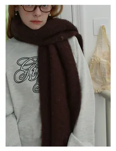 Close-up of thick dark brown wool scarf featuring soft fluffy texture and fringe detail