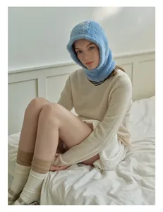 Detail showing the soft faux fur texture of a light blue balaclava on a female model
