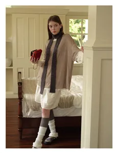 Deep grey long wool blend skinny scarf styled on a model with minimalist indoor outfit