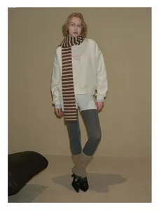 Detailed view of long brown and white striped 100% wool scarf paired with casual outfit