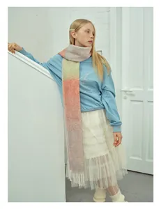 Dettaglio di una morbida sciarpa in mohair sfumato con frange abbinata a una gonna in tulle