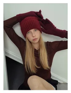 Dettaglio del set invernale in lana di alpaca con berretto rosso in maglia e guanti lunghi