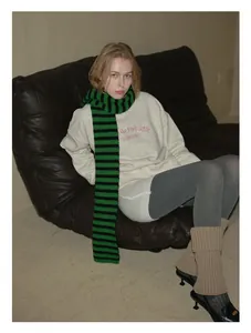 Detail view of a 100% Australian wool scarf featuring bold black and green stripes