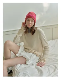 Detailed close-up of pink checkerboard knit beanie with warm ear protection design