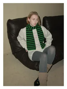 Detailed shot of green and black striped 100% wool scarf styled with a casual outfit