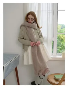 Detail of soft camel wool scarf with fringe tassels worn with a knit cardigan