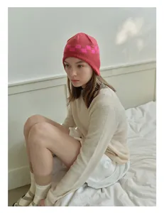 Close-up of pink checkered knit beanie showing soft wool texture and ear protection design