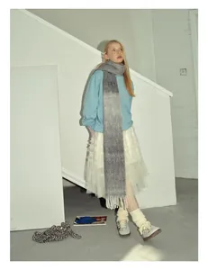 Dettaglio di sciarpa morbida in misto lana sfumata con felpa blu e gonna di tulle