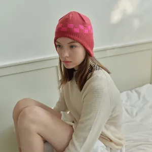Women's checkerboard knit beanie in pink and magenta for autumn winter styling