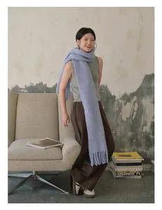Close-up of soft thick lavender wool scarf with long tassels and plush knitted texture