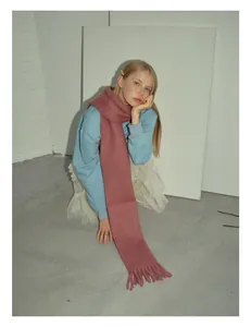 Dettaglio sciarpa rosa in misto lana alpaca e mohair con frange spesse e consistenza morbida