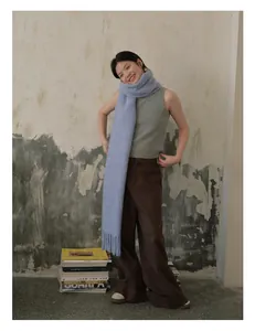 Detail of light blue wool scarf with thick fringe and soft mohair texture finish