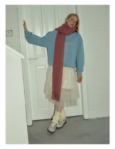 Dettaglio di sciarpa in alpaca e mohair rosa cipria con eleganti frange ai bordi