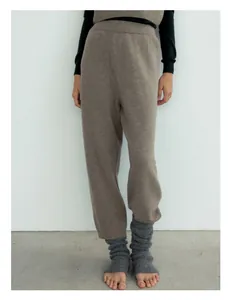 Detailed texture of camel wool blend knit pants with grey leg warmers in a soft studio view