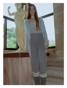 Detail shot of grey wool blend leg warmers styled with knitwear on stone stairs