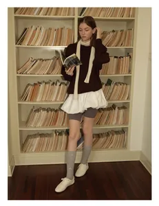 Nahaufnahme des cremefarbenen Strickschals aus Wolle im Vintage-Preppy-Stil in der Bibliothek