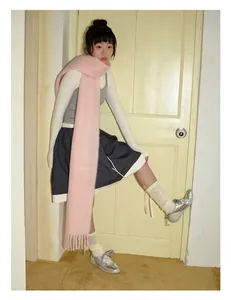 Sciarpa rosa in misto mohair con frange abbinata a una gonna a pieghe grigia