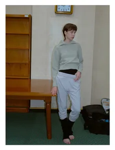Close-up of women's knitted leg warmers styled with light grey joggers and casual wear