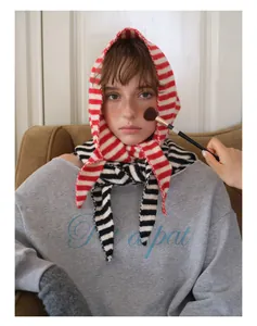 Gros plan du foulard en laine tricotée à rayures rouges et blanches, texture douce