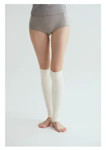 Detailansicht der weißen gerippten Beinstulpen mit vertikaler Strickstruktur für Yoga