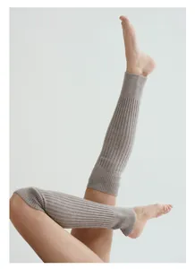 Detail der gerippten Strickstruktur warmer Beinstulpen für Yoga und Ballett in Hellbraun