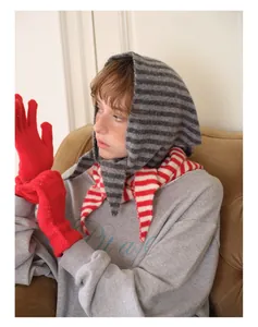 Détail d'une écharpe à capuche rayée en laine et de gants tricotés rouges vifs