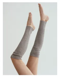 Nahaufnahme hellbrauner Strick-Beinstulpen für Yoga mit weicher Rippenstruktur