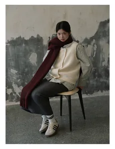 Detail of burgundy wool scarf paired with cream knit vest and long skirt outfit
